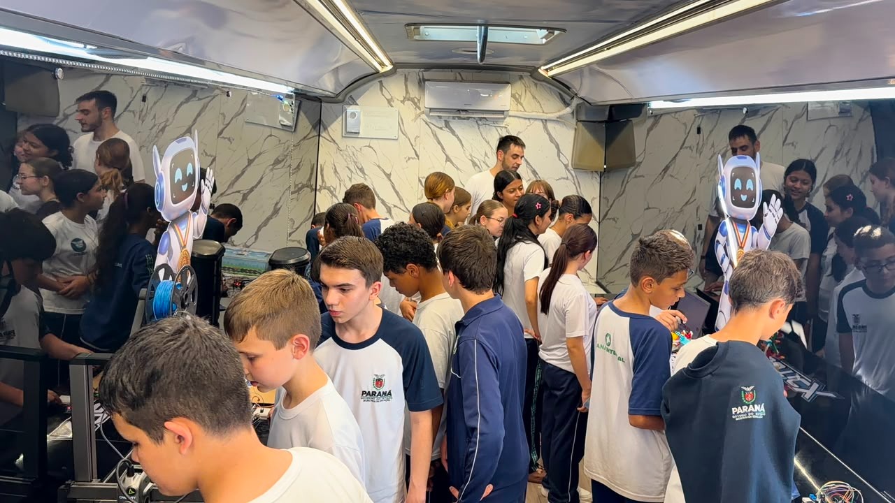 Alunos lotando o interior do ônibus-laboratório RoboticX durante uma aula