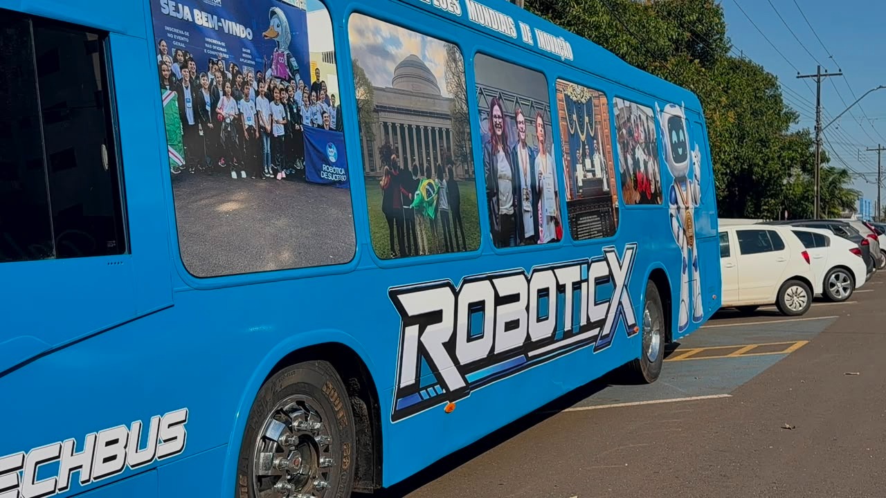 Lateral do ônibus RoboticX com fotos de alunos em competições internacionais